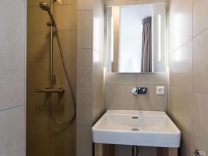 a bathroom with a sink and a shower with a mirror at Villa in Friesland with Jacuzzi and Sauna in Delfstrahuizen +32 photos
