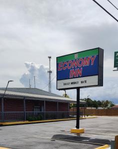 a sign for an economy inn in a parking lot at Economy Inn Motel in Orange