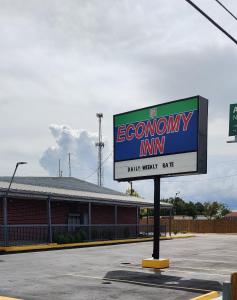 una señal para una posada económica en un estacionamiento en Economy Inn Motel en Orange