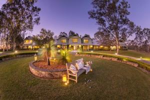 a house with a yard with a chair in front of it at Spicers Vineyards Estate in Pokolbin