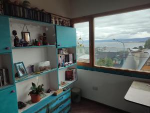 烏斯懷亞的住宿－Alem Casa de Familia，一间设有蓝色架子和窗户的房间