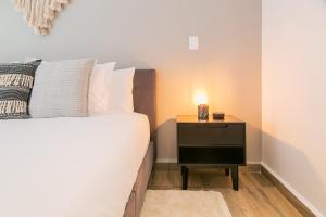 - une chambre avec un lit et une table de chevet avec une bougie dans l'établissement Lumina at Noma Condesa Mexico City, à Mexico