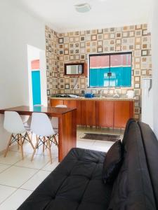 a living room with a couch and a kitchen at Apartamentos Recanto da Barra in Ubatuba