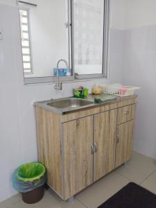 a kitchen with a sink and a mirror at Taiping Comfort Condo Homestay in Taiping