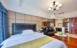 Foshan Yumi Apartment Bodun Branch في فوشان: غرفة نوم مع سرير وغرفة معيشة