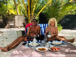 Due persone sedute al tavolo da picnic sulla spiaggia di White Tern Maldives a Maamigili