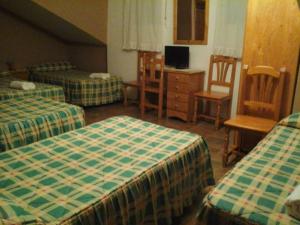 a hotel room with two beds and a chair at Hostal Piñera in Vega de Espinareda