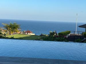 una piscina con el océano en el fondo en Private Villas of Bali, en Nusa Dua