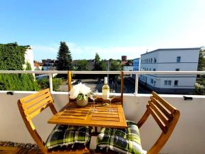 una mesa de madera con 2 sillas en el balcón en Stilvolles Apartment mit Balkon, en Wilhelmshaven