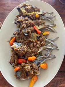 a plate of food with meat and vegetables on a table at Private Villas of Bali in Nusa Dua