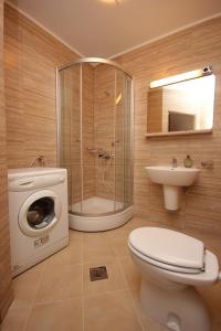 W łazience znajduje się toaleta, prysznic i pralka. w obiekcie Apartments by the sea Cavtat, Dubrovnik - 8826 w mieście Cavtat