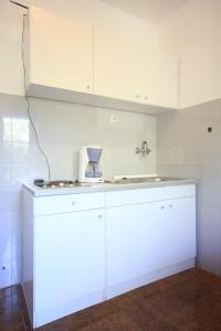 a kitchen with white cabinets and a blender on a counter at Apartments by the sea Cavtat, Dubrovnik - 8827 in Cavtat