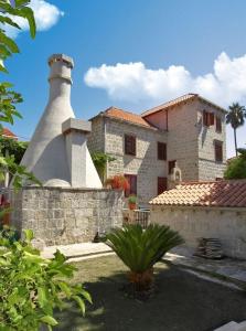 ein Gebäude mit einem Leuchtturm vor einem Haus in der Unterkunft Apartments and rooms by the sea Cavtat, Dubrovnik - 8974 in Mlini