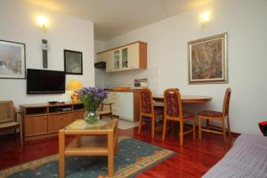 ein Wohnzimmer mit einer Küche und einem Tisch mit Stühlen in der Unterkunft Apartments and rooms by the sea Cavtat, Dubrovnik - 8974 in Mlini