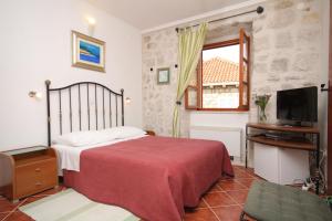Schlafzimmer mit einem Bett, einem TV und einem Fenster in der Unterkunft Apartments and rooms by the sea Cavtat, Dubrovnik - 8974 in Mlini