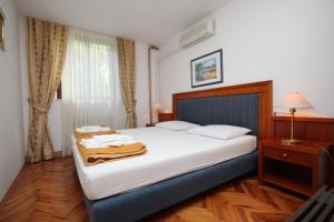 a bedroom with a large bed with white sheets and a table at Apartments with a parking space Cavtat, Dubrovnik - 8986 in Mlini