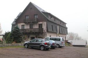 zwei Autos auf einem Parkplatz vor einem Haus geparkt in der Unterkunft Hotel Na Vyhlidce in Kořenov