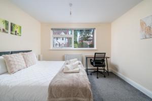 a bedroom with a bed and a desk and a window at Redhill Surrey 2 Bedroom Pet Friendly Apartment by Sublime Stays in Redhill