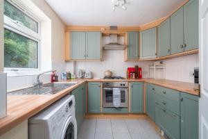 una cucina con armadi blu e lavastoviglie di Redhill Surrey 2 Bedroom Pet Friendly Apartment by Sublime Stays a Redhill