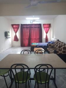 a room with a table and chairs and a couch at Haji Din Cocobay Condo in Port Dickson