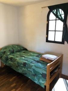 a bedroom with a bed in a room with a window at Casa Calo Bialet Massé in Bialet Massé