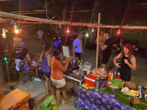 a group of people standing around a table with food at Boy Scouts Homestay in Ban Nua