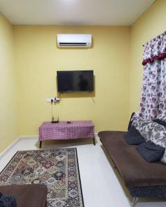 uma sala de estar com um sofá e uma televisão de ecrã plano em SMZ Café & Homestay - SELF CHECK IN em Kodiang