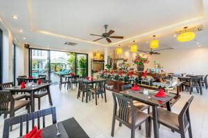 una sala da pranzo con tavoli e sedie e un ristorante di Banana Garden Villa a Hoi An