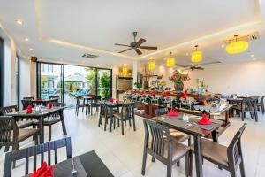 un comedor con mesas y sillas y un restaurante en Banana Garden Villa, en Hoi An