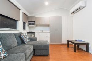 a living room with a couch and a table at Aspen Karratha Village in Karratha