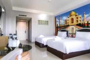 um quarto de hotel com duas camas e um quadro na parede em BCP Hotel em Ban Chang