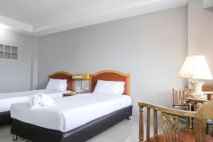 1 dormitorio con 2 camas, mesa y lámpara en BCP Hotel en Ban Chang