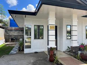 uma casa branca com um telhado preto em Davao Transient Villa with 24hrs security guard BBQ Grill , Free Parking and Wifi em Davao