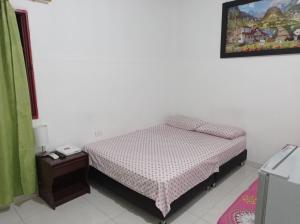 Habitación pequeña con cama y mesita de noche en Hotel Acuarius, en Cúcuta