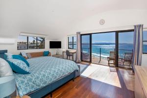 a bedroom with a bed and a view of the ocean at Eclipse Absolute Beachfront with Stunning Views in Culburra Beach