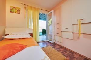 a bedroom with a bed and a sliding glass door at Holiday home Villa Linda - big terraces in Seget Vranjica