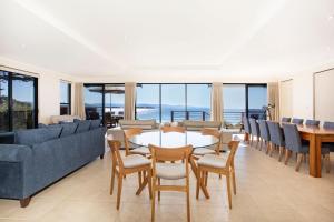 a living room with a table and chairs at Eclipse Absolute Beachfront with Stunning Views in Culburra Beach