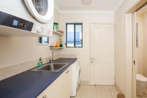 a kitchen with a sink and a microwave at Eclipse Absolute Beachfront with Stunning Views in Culburra Beach +31 photos