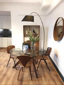 a dining room with a glass table and chairs at Vichy : Le 5e - Appartement design dans un ancien palace in Vichy