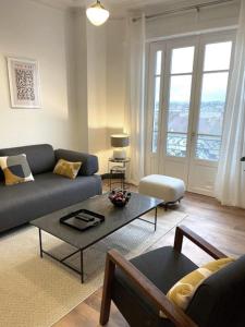 a living room with a couch and a table at Vichy : Le 5e - Appartement design dans un ancien palace in Vichy