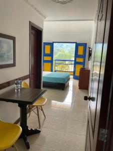 Zimmer mit einem Tisch und Stühlen sowie einem Schlafzimmer in der Unterkunft Hospedaje Camino Real a 150 MTS del centro in Salento
