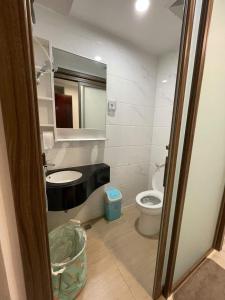 a bathroom with a sink and a toilet and a mirror at Precious Angel Apartment Sky House BSD in Pagedangan