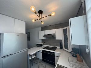 a kitchen with white cabinets and a refrigerator at Comfortable apartment with parking, best location in Guadalajara