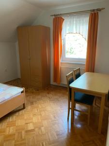 1 dormitorio con mesa, cama y ventana en KMETIJA KNAVS en Nova Vas