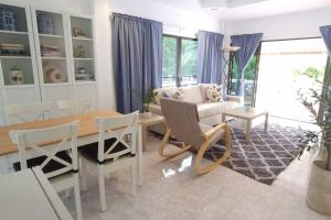 sala de estar con mesa y sofá en Lovely 2-Bedroom Condo with Pool, en Kamala Beach