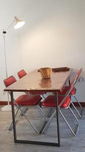 a dining table with red chairs and a lamp at Loft Salto Chico in Concordia