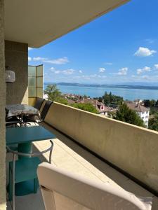 d'un balcon avec une table et une vue sur l'eau. dans l'établissement Alpes 54, à Neuchâtel