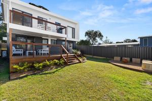 a house with a deck and a fence at Bella Vita by Experience Jervis Bay in Vincentia