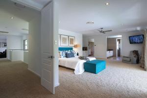 YaroombaにあるYaroomba Beach Houseの広いベッドルーム(ベッド1台、青いソファ付) +24枚の写真