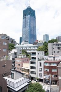 a view of a city with a tall skyscraper at Ken's Place麻布East in Tokyo